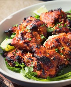 a white bowl filled with meat and greens