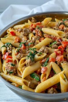 a bowl filled with pasta and meat on top of a table