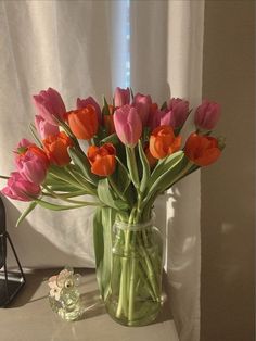 a vase filled with pink and orange tulips