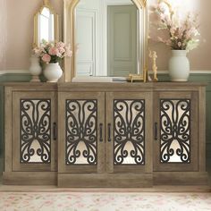 an ornate sideboard with mirrors and vases on it