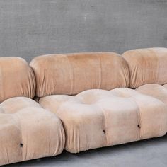 a beige couch sitting on top of a cement floor