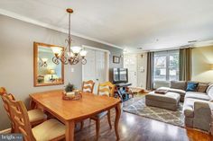 a living room and dining area with hardwood floors, couches, table and chairs