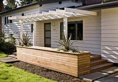 a small white house with a wooden planter