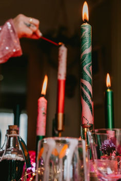 a table topped with candles and glasses filled with liquid