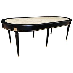 a black and white marble top table with gold trimmings on the legs,