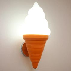 an orange ice cream cone is on the wall next to a light fixture with a white bulb