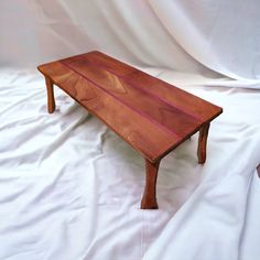 a wooden table sitting on top of a white sheet