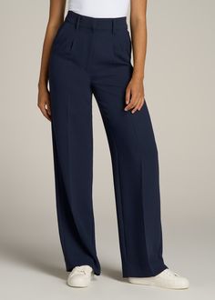 About Our Extra-Long Women’s Dress Pants Make a statement in these stylish pleated women’s tall dress pants. Pleated trousers are a timeless trend you’ll love and now, there’s finally a pair that will accentuate your long legs. These pants for tall women have been designed specifically for ladies between 5’9” and 6’6”, with a full length offering extra-long inseam options. They have a high-rise silhouette that gives the appearance of a cinched waist, complete with a fly zipper and hook and bar c Pants Design For Women, Long Pants Women, Navy Blue Pants Women, Tailor Trousers Women, Formal Pant Designs For Women, Blue Formal Pants Women, Dress Pants Outfits Women, Trending Trousers For Women, Pants Trousers For Ladies