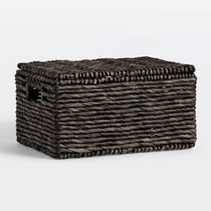 an empty wicker box with handles on the top and bottom, sitting in front of a white background