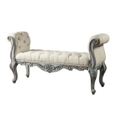 an antique style bench with white upholstered fabric