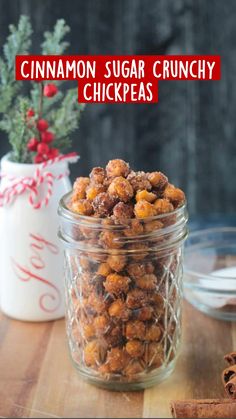 cinnamon sugar chickpeas in a glass jar on a wooden table next to a christmas tree