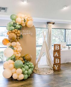 a baby shower is decorated with balloons and greenery