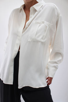 The Nora Relaxed Button Up is a thoughtfully constructed blouse with a focus on tailored details and a functional fit. A refreshing tailored button-up, essential year round, the Nora features a front hidden placket, pleated chest pocket, relaxed sleeves, and generous cuffs. Classic Button-up Blouse With Welt Pockets, Timeless Daywear Blouse With Concealed Placket, Timeless Button-up Top With Hidden Buttons, Modern Formal Tops With Pockets, Timeless Relaxed Fit Shirt For Work, Timeless Relaxed Fit Workwear Shirt, Timeless Relaxed Fit Tops With Button Closure, Office Collared Top With Welt Pockets, Collared Office Tops With Welt Pockets