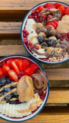 two bowls filled with different types of fruit on top of a wooden table next to each other