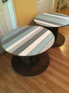 two tables made out of wood sitting on top of a hard wood floor next to a door