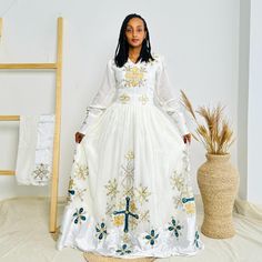 This stunning neutral-colored Habesha dress combines the subtle elegance of beige and grey tones with intricate beadwork that exudes sophistication. Designed with delicate hand-beaded details along the neckline and sleeves, this Ethiopian traditional dress is perfect for those who appreciate understated elegance. The soft, flowing fabric makes it ideal for both everyday wear and special occasions.  Key Features: Cultural Heritage: Adorned with exquisite handwoven details that honor Ethiopia's rich traditions. Flattering Design: The flowing silhouette ensures you look stunning at weddings, festivals, or any event where you want to shine. Ethical Craftsmanship: Handmade by skilled Ethiopian artisans, embracing tradition while making a bold fashion statement. Care Instructions: For best resul Habesha Dress, Ethiopian Traditional Dress, Habesha Kemis, Flowing Fabric, Subtle Elegance, Grey Tones, Traditional Dress, Understated Elegance, Cultural Heritage