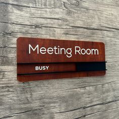 a wooden sign that says meeting room busy