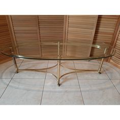 a glass table sitting on top of a tile floor next to a wooden paneled wall