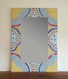 a colorful mirror sitting on top of a wooden table