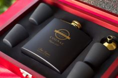 two black flasks in a red box with gold trimming on the top