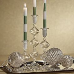 a silver tray with candles and seashells on it