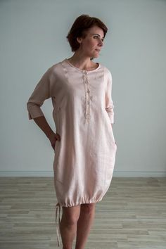 Loose fit linen button up tunic. Soft linen dress with three quarter sleeve and intricate details. FEATURES:Boat necklineButton up frontTie up bottomThree quarters dolman sleeveRuffle sidesPocketsModel is 174 cm/5'7" tall, size S-M. SIZE:S-M | EU 36-38 | US 6-10-Chest 110 cm / 43.3"-Back Center Length 93 cm / 36.6"-Hips 118 cm | 46.4"M-L | EU 38-42 | US 10-12L-XL | EU 42-46 | US 12-16COMPOSITION:100% - local medium weight linenOeko-Tex certified 100 % linen fabric* IMPORTANT: We can make clothes Spring Linen Dress With Button Closure, Spring Button-up Tunic With Buttons, Casual Linen Dress With Button Cuffs For Spring, Relaxed Fit Linen Dress With Buttons For Daywear, Summer Linen Dress With Button Cuffs For Daywear, Spring Daywear Linen Dress With Button Closure, Summer Tunic With 3/4 Sleeves For Daywear, Linen Daywear Dress With Button Cuffs, Spring Linen Dress With 3/4 Sleeves, Relaxed Fit