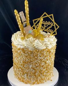 a birthday cake decorated with gold and white frosting