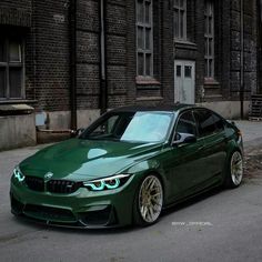 a green car parked in front of a brick building