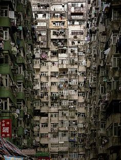 an alley way with lots of windows and balconies on the buildings in hong kong