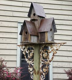 a wooden bird house sitting on top of a pole