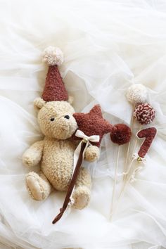 a teddy bear with a hat and two candy lollipops