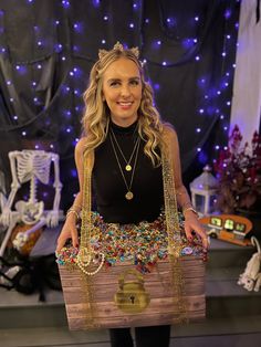 a woman is holding a wooden trunk with beads and chains on it while posing for the camera