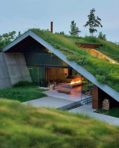 an unusual house with grass on the roof