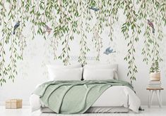 a bed sitting under a green tree with birds on it's head and leaves hanging from the branches