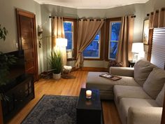 a living room filled with furniture and a flat screen tv sitting on top of a hard wood floor