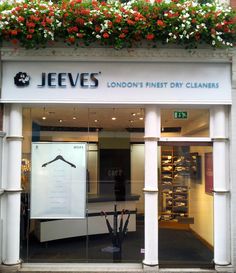 a store front with flowers on the window