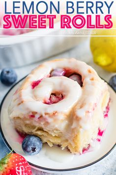 lemon berry sweet rolls on a plate with blueberries and strawberries in the background