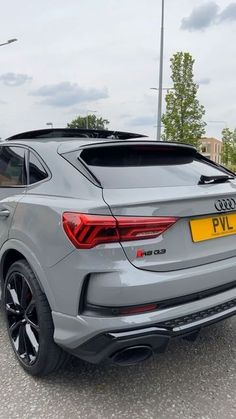 the rear end of an audi suv parked in a parking lot with other cars behind it