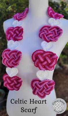 a white mannequin with pink and white crocheted hearts attached to it