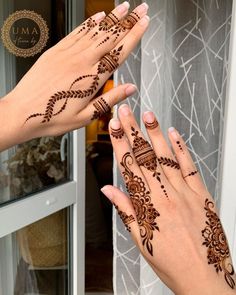 two hands with henna designs on them