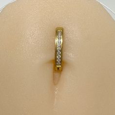 a gold ring with three small diamonds on it's side, sitting on top of a mannequin