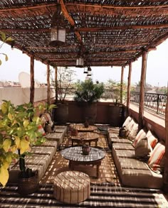 an outdoor living area with couches, tables and potted plants on the roof