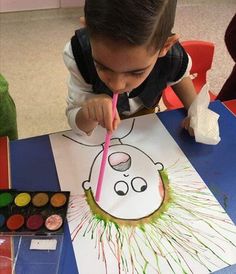 a young boy is painting with colored pencils