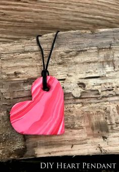 a pink and red heart shaped pendant on a black cord with the words diy heart pendant