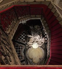 an ornately decorated stair case in the middle of a room with red and white walls