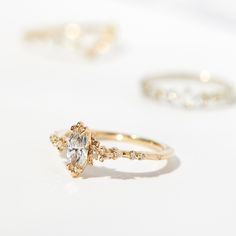 three wedding rings and an engagement ring on a white surface