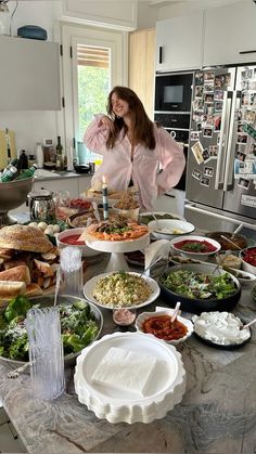 a woman standing in front of a table full of food