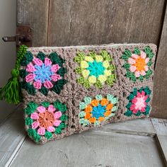 a crocheted purse sitting on top of a wooden door