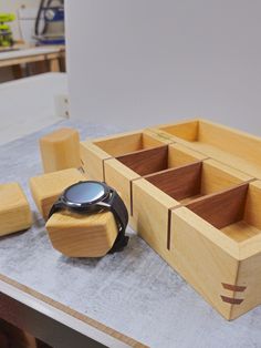 a watch and wooden boxes on a table