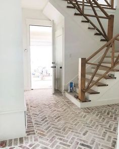 an instagram photo of a house with stairs and brick flooring in the hallway